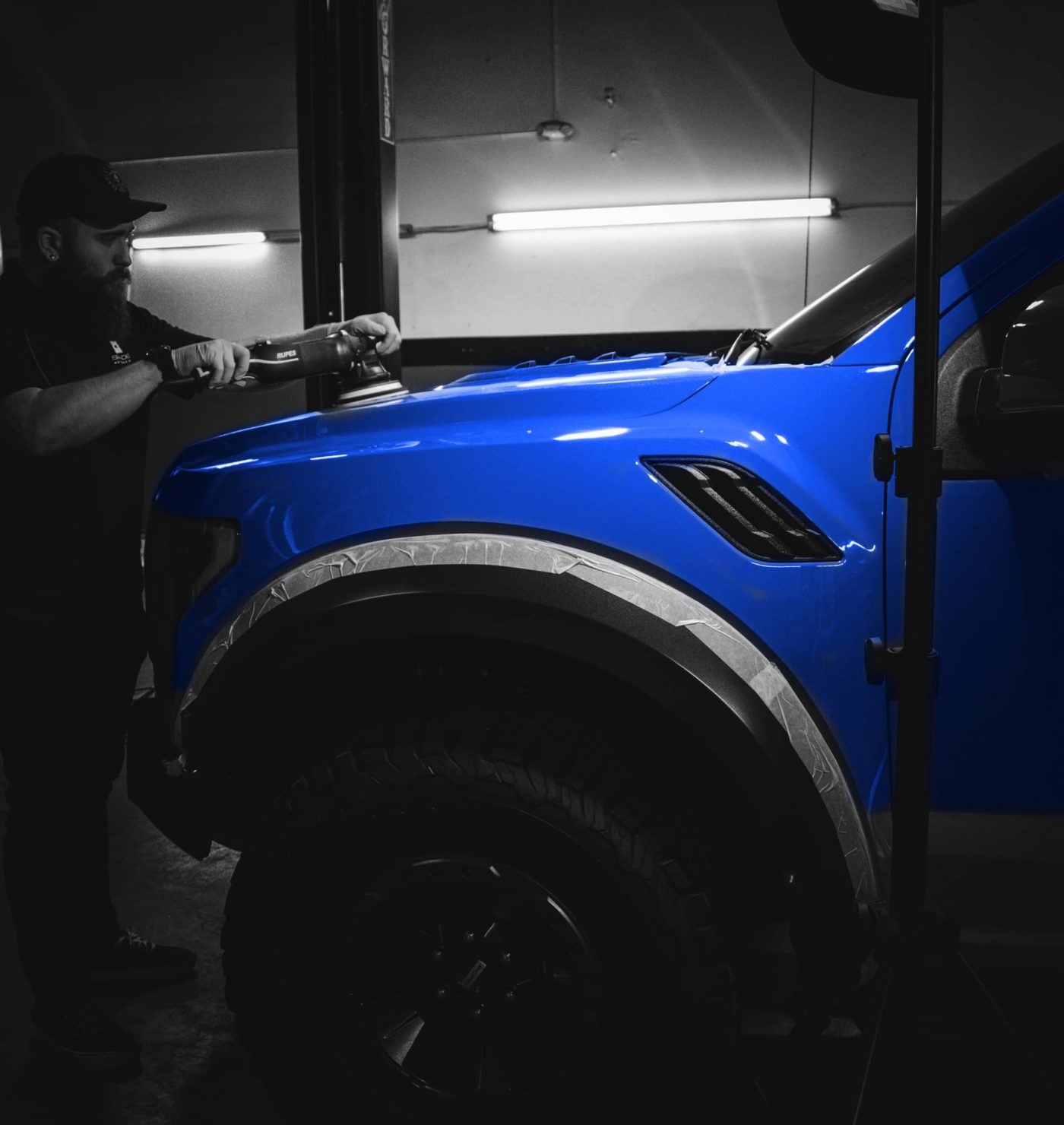 Technician working under the side of a vehicle in the workshop