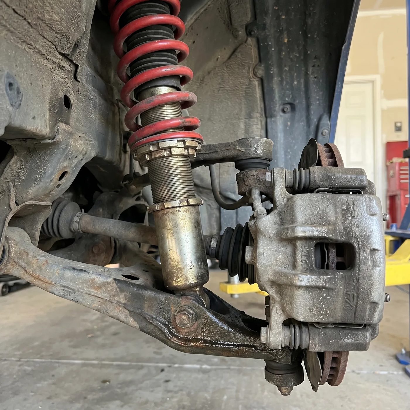 Front suspension strut and control arm viewed from underneath a vehicle